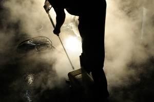 James Lowe powerwashes grill equipment behind a Dairy Queen in Elizabethtown, Kentucky at 4 a.m.  Lowe, an Irish native, came to the U.S. to work for his family's business Flame Control which cleans industrial equipment.